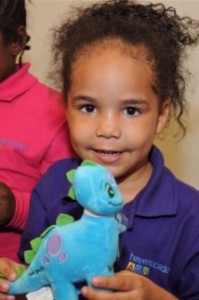 Foster girl with stuffed dinosaur